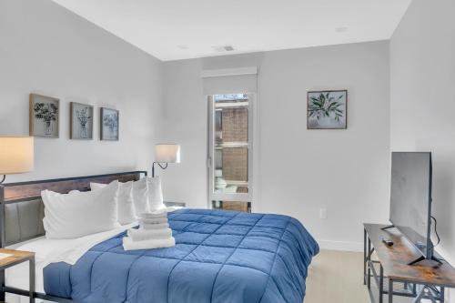 华盛顿Fully Furnished Apartment in Washington near Logan Circle的一间卧室配有蓝色的床和电视