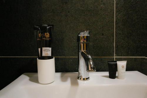 怡保Golden Roof Hotel Sunway Ipoh的浴室盥洗盆配有牙刷和水龙头
