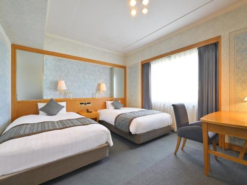 高松高松国际大酒店的酒店客房配有两张床和一张书桌