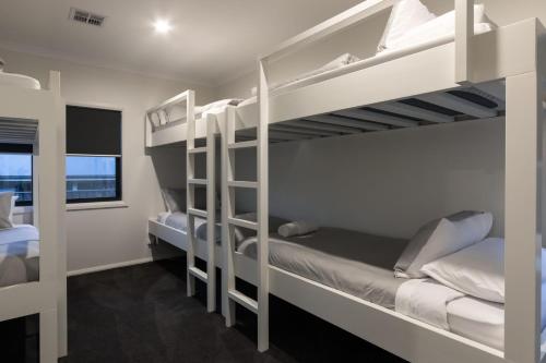 布赖特Mountain Mist Retreat - 6 Bedrooms的客房设有两张双层床和一扇窗户。