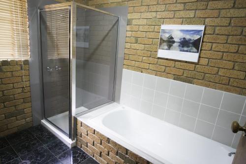 布赖特Monty's on Lumley Drive的带淋浴的浴室(带瓷砖墙)