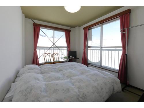 关市Ishiuchi Ski Center - Vacation STAY 09176v的一间卧室设有一张大床和两个窗户。
