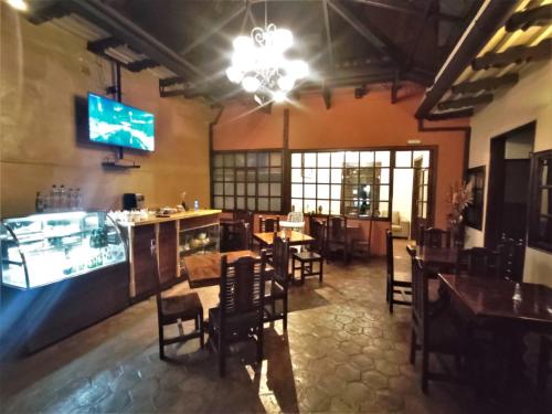 昆卡Hotel Calle Angosta的餐厅设有酒吧和桌椅