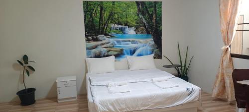 Ban Bo Sai KlangBatikseafood Airport & Room的卧室配有一张壁挂瀑布壁画的床。