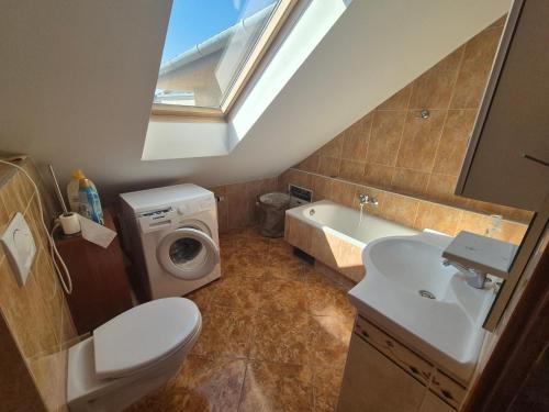 凯奇凯梅特Charm Grand Suites Apartment的浴室配有卫生间水槽和洗衣机。