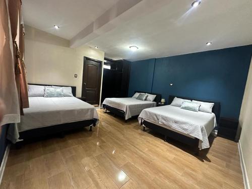 圣胡安拉拉古纳CASA DE DESCANSO TZANJAAY的一间设有两张床和蓝色墙壁的客房