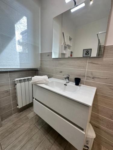 菲乌米奇诺Coho House Fiumicino的浴室设有白色水槽和镜子