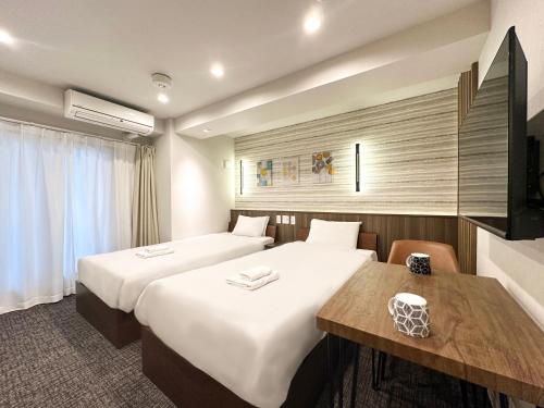 大阪大阪惠比寿酒店的酒店客房设有两张床和一张桌子。