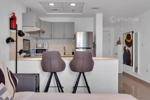 迪拜Sleek Studio - Red Residence-L8 - Near ISD Stadium的厨房在柜台前配有两把椅子