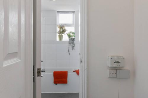 诺丁汉Perfect Retreat 4bed House Trent Bridge & Forest的浴室提供橙色毛巾和窗户。