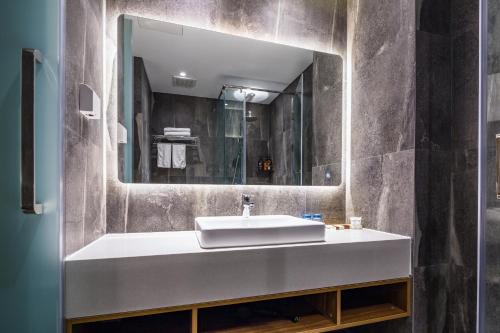 青岛青岛美墅假期酒店（五四广场万象城店）的一间带水槽和镜子的浴室