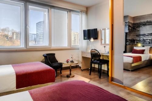 伊斯坦布尔Cheya Besiktas Istanbul Bosphorus City Center Hotel & Suites的酒店客房配有两张床和一张书桌