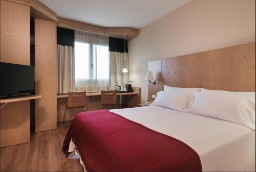洛格罗尼奥Hotel Logroño Parque的酒店客房设有一张大床和一张书桌。