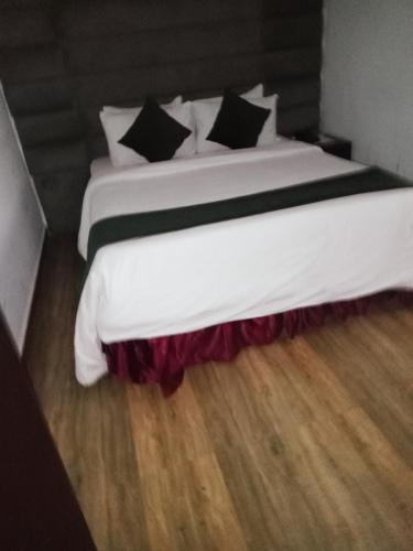 拉各斯Jada Lifestyle & Lounge的卧室配有一张带黑色枕头的大型白色床。