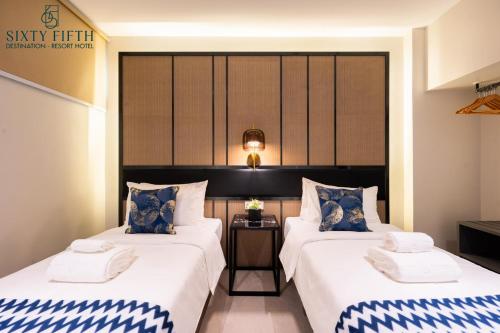 巴科洛德SixtyFifth Destination Resort Hotel的酒店客房设有两张床和一张桌子。