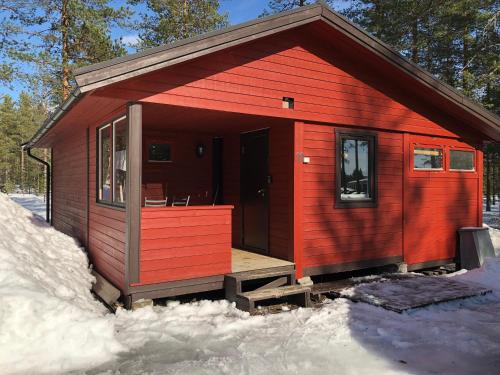 瑞纳Rena Hostel IVAR的雪中带门廊的红色小屋
