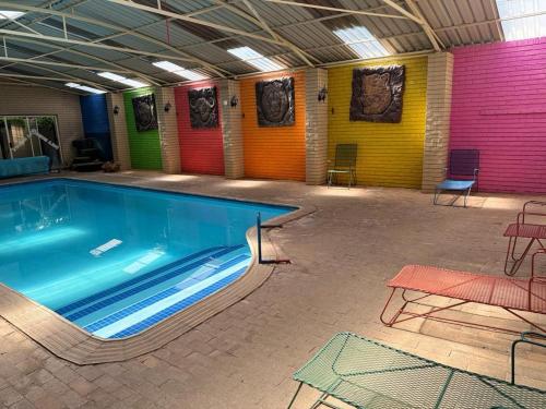 贝拉贝拉Dula Monate Holiday Flats的色彩缤纷的墙壁,房内设有一个大型游泳池