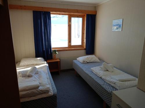 SkarsvågArctic Lodging North Cape的带窗户的客房内的两张床