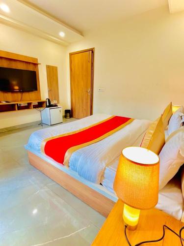 古尔冈Amahi Inn - Sector 48的一间卧室配有一张大床,提供红色和黄色的毯子