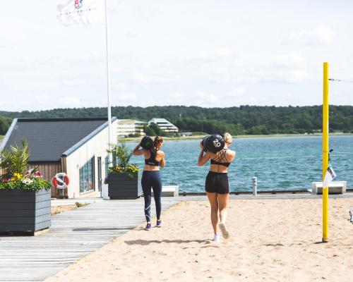 斯泰农松德斯特努斯巴登游艇俱乐部酒店的两名穿着泳衣的妇女在海滩上散步