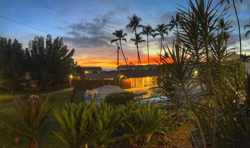 科纳Your Slice of Paradise in Kona的享有房子的景色,背景是日落