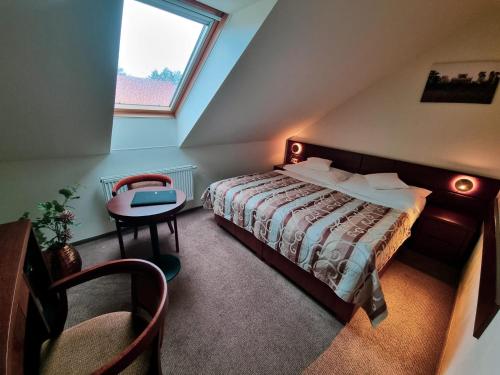 雷德尼斯马里奥酒店的一间卧室配有一张床、一张桌子和一个窗户。