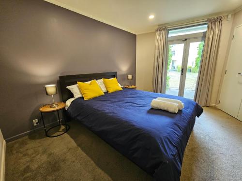 惠灵顿Executive, Spacious & Modern Home, 8 Beds!的一间卧室配有一张带黄色枕头的大型蓝色床