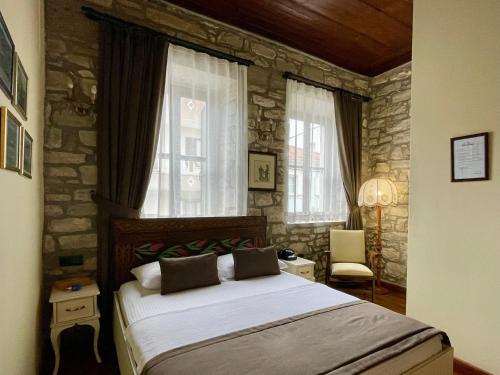 伊兹密尔Urla Taş Konak Otel的一间卧室设有一张床和石墙
