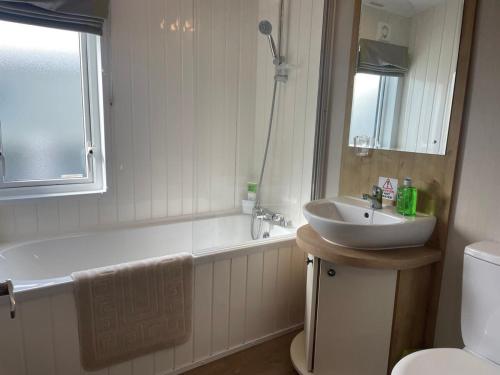 佩文西42 Woodland Walk Pevensey Bay Holiday Park sleeps 6的一间带水槽、浴缸和卫生间的浴室