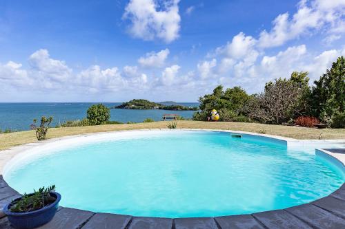 勒弗朗索瓦Maison d'Ô Pointe Thalémont, avec petite crique privative的享有水景的大型蓝色游泳池