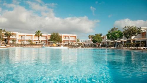 科拉雷侯罗伯斯海湾拉布兰达酒店的度假村的游泳池,配有椅子和遮阳伞