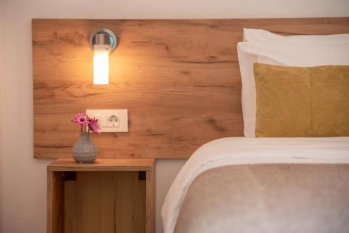 基萨莫斯Kaliviani Traditional Hotel的一间卧室配有一张床,一个花瓶摆放在桌子上