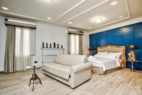 维洛里奥萨50th Guest House的一间卧室配有白色的沙发和蓝色的墙壁