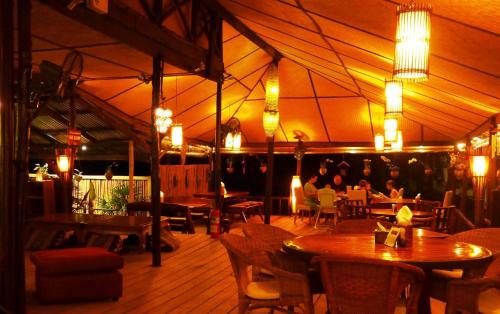 象岛安布尔沙滩度假村的一间设有桌子的餐厅,人们坐在帐篷里