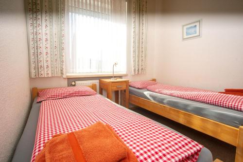 诺德奈Haus Ufen - In den Dünen 18c的带窗户的客房内设有两张单人床。