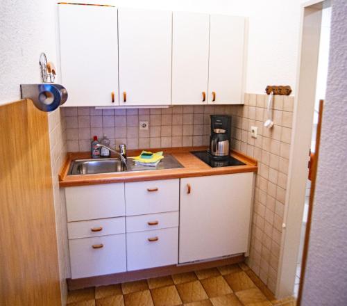 诺德奈Haus Ufen - In den Dünen 18c的厨房配有白色橱柜和水槽