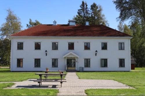 GarderStudio Apartments Oslo Airport的一座白色的大建筑,前面设有一张野餐桌