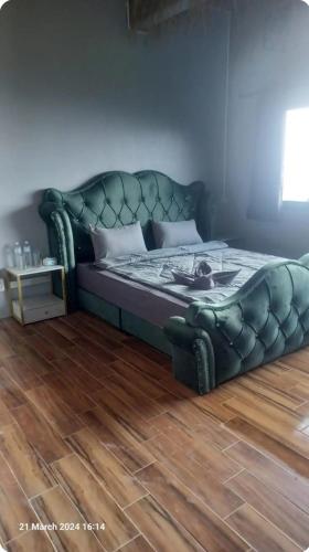 涛岛Exotic Stay Koh Tao的一张位于带绿色皮沙发的房间内的床铺