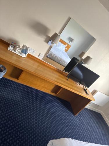 阿夫雷Thurrock Hotel M25 Services的一间卧室配有一张床和一张带镜子的书桌