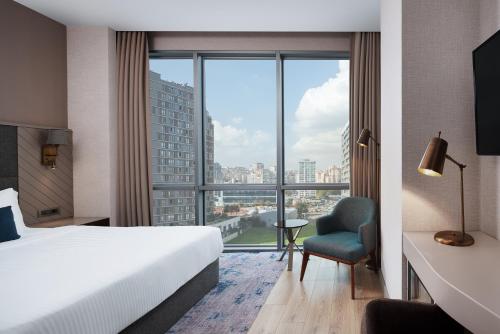 伊斯坦布尔Delta Hotels by Marriott Istanbul Kagithane的酒店客房设有一张床和一个大窗户