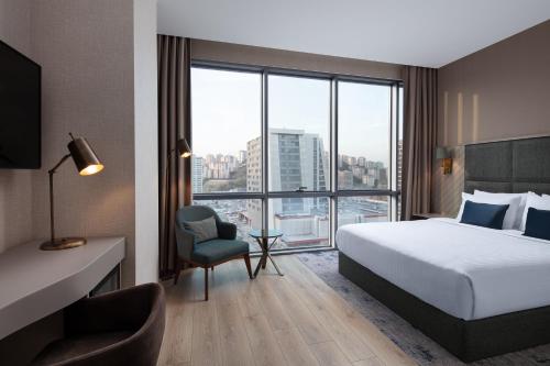 伊斯坦布尔Delta Hotels by Marriott Istanbul Kagithane的酒店客房设有一张床和一个大窗户