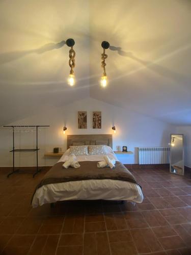 佩德罗－穆尼奥斯LA MANCHA SUITES CASA RURAL的一间卧室配有一张大床和两条毛巾