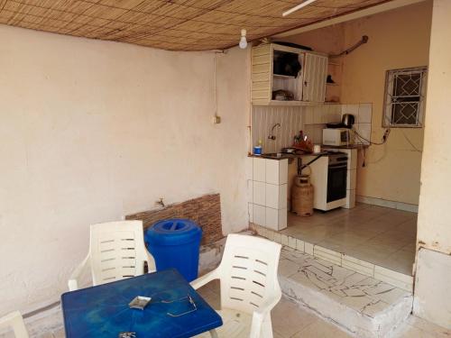 比绍Casa Cacheu low cost family house的一间设有桌子和两把椅子的房间和一间厨房