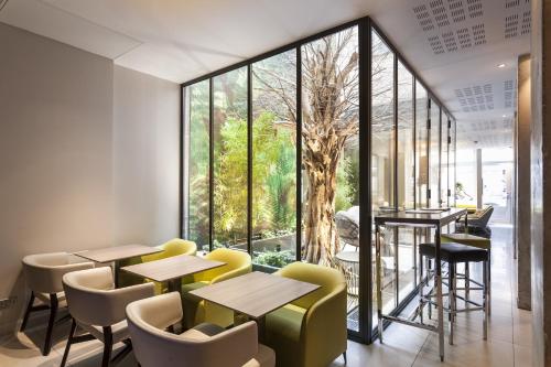 巴黎杜尔酒店的餐厅设有桌椅和大窗户。