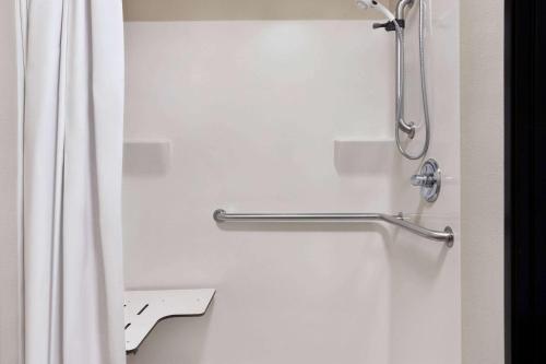 麦卡莱斯特Travelodge by Wyndham McAlester的带淋浴帘和卫生间的浴室