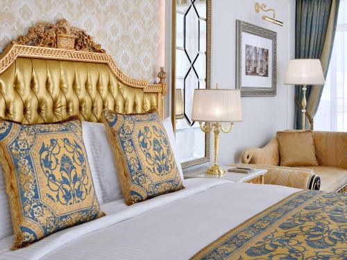 迪拜Raffles The Palm的一间卧室配有一张大床和金色床头板