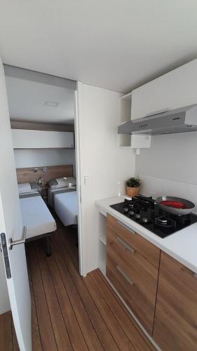利多克拉西Minicasetta sul mare 1的一间带炉灶的厨房和一张位于客房内的床。