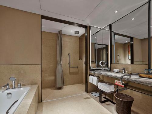 保定保定中博希尔顿逸林酒店的带浴缸、水槽和浴缸的浴室