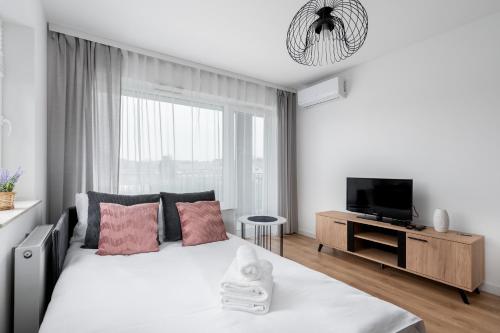 克拉科夫Prokocim Kosocicka Apartment的一间白色卧室,配有床和电视