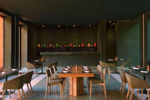 BenguerirDoubletree By Hilton Ben Guerir Hotel & Residences的一间带桌椅和柜台的餐厅